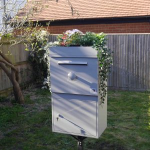 Eine große Paketbox mit einem Dachgarten in einem Garten